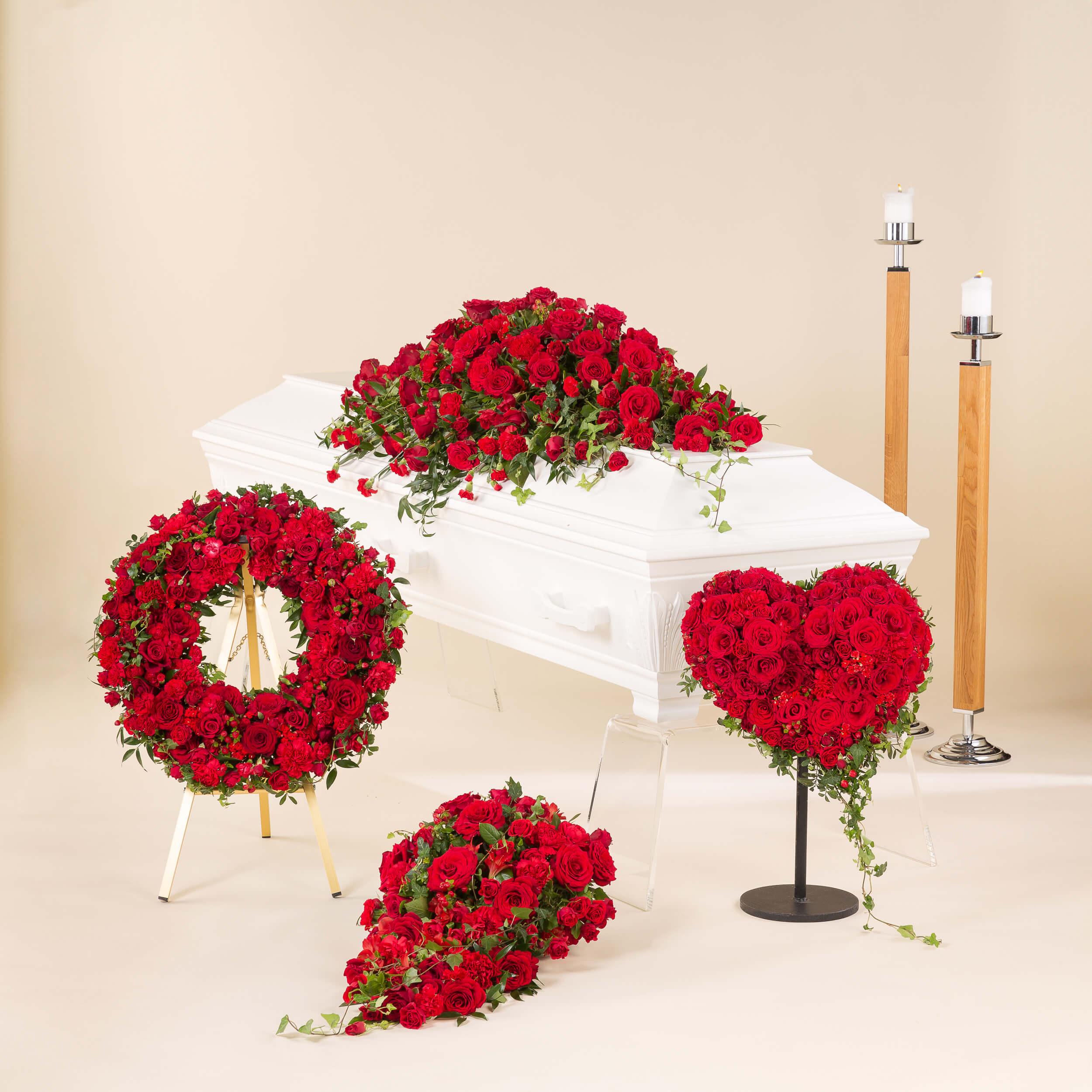 Blomster til begravelse med rød kistedekorasjon, krans, hjerteformet begravelseskrans og bårebukett i røde blomster.